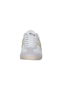 White sneaker with beige suede toe cap and side stripes, featuring white laces and a textured sole. Includes brand logo on the tongue.