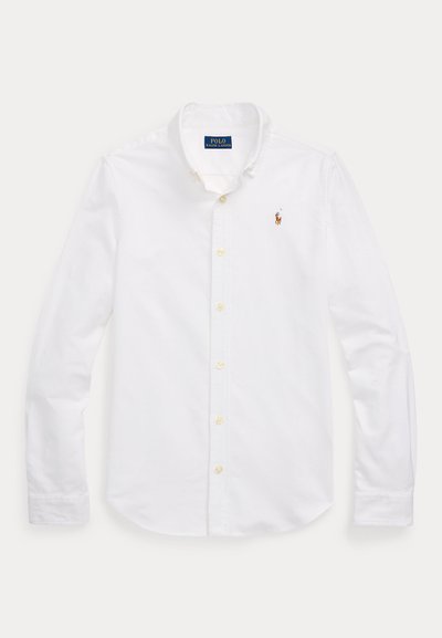 Camisa blanca de manga larga abotonada con cuello, que muestra un pequeño logo bordado de Polo Ralph Lauren en el pecho izquierdo.