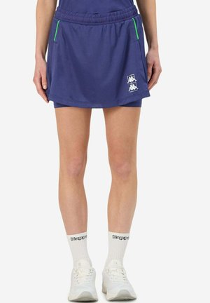 Skort de sport bleu marine avec taille élastique, poches à accents verts et détail de logo blanc. Le tissu présente un motif texturé.