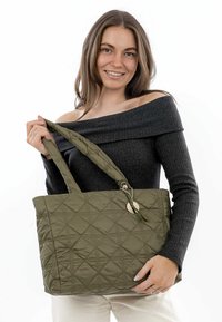 Sac cabas matelassé vert olive avec motif en losanges, poignées doubles et accent métallique sur une chaîne. Fabriqué en tissu résistant.
