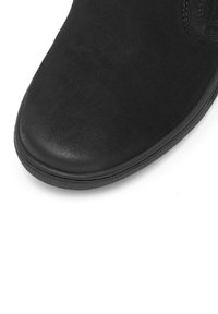 Czarne zamszowe botki za kostkę z okrągłym noskiem, gładką fakturą i kontrastującą gumową podeszwą. Minimalistyczny design bez widocznych elementów metalowych ani akcentów.