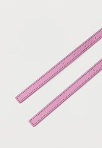 Cinghie in pelle rosa con una texture liscia, caratterizzate da cuciture a contrasto e fori distribuiti in modo uniforme per una chiusura regolabile.