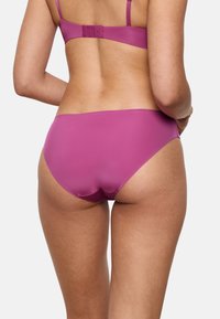 Figursyet lilla bikini sæt med glat stof, justerbare stropper og lukkemekanisme bagpå med fire hægteindstillinger; minimal dækning på bunden.