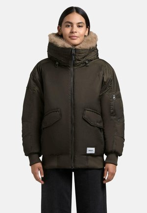Dunkelgrüne isolierte Jacke mit gefütterter Kapuze, Reißverschluss, großen Vordertaschen und gerippten Bündchen. Verfügt über eine auffällige Seitentasche mit Reißverschluss.