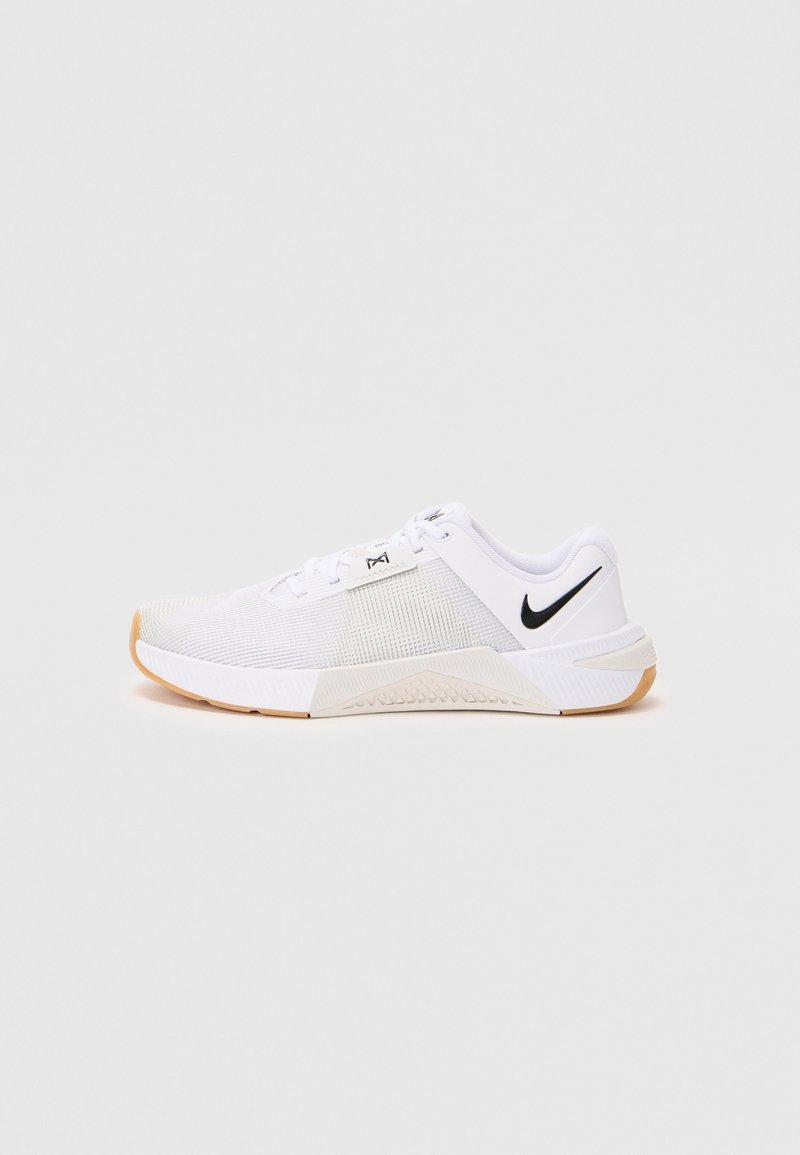 Men's white Nike athletic shoe with black swoosh logo, mesh upper, and gum-colored sole, shown from the side on a white background.