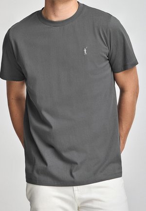 Grå bomulds t-shirt med rund hals og korte ærmer, med en lille hvid logo af en figur, der svinger en kølle på venstre bryst.