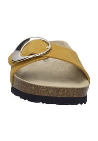 Gelbe Slipper-Sandale mit einem breiten Riemen und einem silbernen Schnallendetail. Verfügt über ein gepolstertes Korkfußbett und eine schwarze Gummisohle.