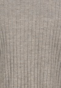 Beiger gerippter Strickstoff mit vertikalen Linien, der ein weiches und gemütliches Materialmuster zeigt.