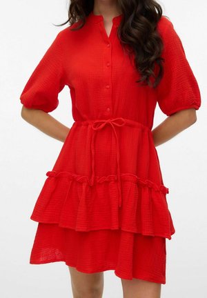 Czerwona sukienka do kolan wykonana z fakturowanego materiału, z przodem na guziki, krótkimi bufkami i wiązanym w talii paskiem z falbaną na dole.