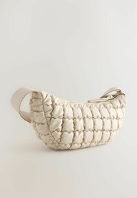 Beige quiltet håndtaske med en rund form, lavet af glat, polstret materiale, med en lynlåslukning og en enkelt rem.