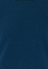 Námořnický modrý sweatshirt vyrobený z měkkého materiálu, s kulatým výstřihem a hladkou texturou. Jemný šev na lemu.