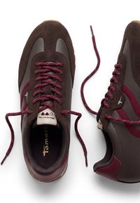 Paire de baskets marron et bordeaux avec des lacets grenat, des détails en daim et en cuir, et des semelles intérieures de marque sur fond blanc.