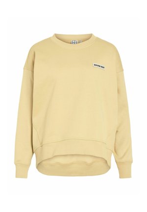 Béžová oversize mikina s okrúhlym výstrihom, dlhými rukávmi a malou nášivkou "ROUGE EDIT" na hrudi, rebrovanými manžetami a lemom.