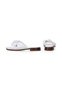 Hvide slip-on sandaler med en knyttet stofoverdel, åben tå og en lav træhæl. Glat tekstur med enkelt design og uden synligt hardware.