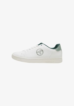 Zapatilla blanca de corte bajo con interior y detalle en el talón en verde, diseño con cordones y logo circular en el lateral.