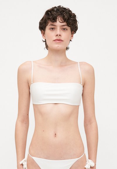 Biały biustonosz bikini z cienkimi ramiączkami i fasonem bandeau, w zestawie z pasującymi majtkami bikini z wiązaniami po bokach.