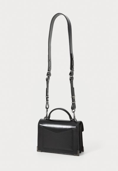 Black leather handbag with a structured shape, short handle, detachable shoulder strap, and a front pocket featuring a triangular flap.