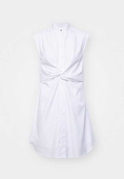 Bela brezrokavna obleka z visokim ovratnikom, sprednjim zapiranjem na gumbe in zavezanjem v pasu. Gladek material z rahlim sijajem.