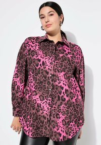 Leopardenmusterhemd in Pink und Braun, knöpfbares Design, lange Ärmel, zwei Brusttaschen, weicher Stoff mit leicht strukturiertem Erscheinungsbild.