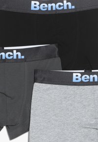 Trois paires de boxers en noir, gris et gris clair. Dotés de ceintures élastiques avec le logo "Bench." en bleu clair. Tissu doux.