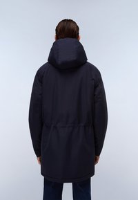 Námořnická modrá parka s kapucí, elastickým pasem a dlouhými rukávy. Textura je hladká a voděodolná. Minimalistický design.