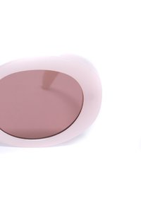 Apaļas saulesbrilles ar maigi rozā rāmjiem un brūniem lēcu tonējumiem. Rāmis ir gluds un nedaudz caurspīdīgs, uzsverot mūsdienīgu dizainu.