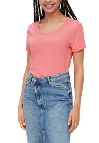 T-shirt à manches courtes et décolleté bateau en corail doux, fabriqué dans un tissu léger ; associé à une jupe en denim taille haute avec un délavage décoloré.