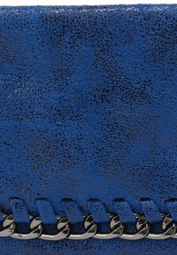 Niebieska skórzana kopertówka o teksturowanym wykończeniu, z łańcuszkiem i wyszukanym przeszyciem wzdłuż krawędzi. Kompaktowy, prostokątny kształt.