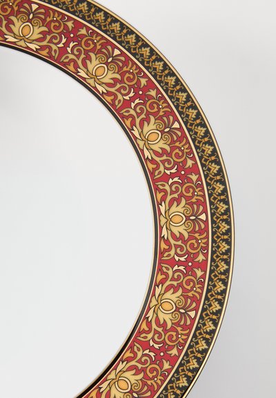 Prato de cerâmica com padrão floral vermelho e dourado na borda, apresentando detalhes pretos intrincados e interior branco liso.