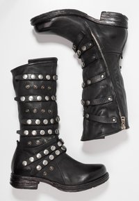 Czarne skórzane botki za kostkę z wieloma srebrnymi ćwiekami i paskami. Posiadają zamek błyskawiczny z boku oraz teksturowaną podeszwę dla lepszej przyczepności.
