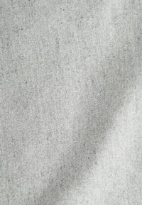 Helles graues Gewebe mit einer weichen Textur, das ein dezentes Muster aus dunkleren Fasern aufweist, die durchgewebt sind und ein einheitliches Erscheinungsbild schaffen.