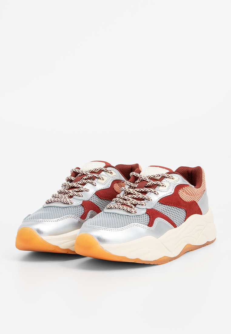 Atletiek sneakers met een zilver metallic bovenwerk, bordeauxrode en mesh accenten, dikke witte en gum zool, en met patronen uitgevoerde veters.
