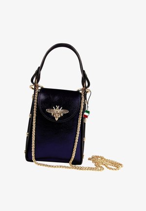 Small glossy black handbag with gold bee ornament on front flap, gold chain strap, black top handle, and Italian flag charm attached.