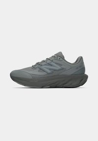 Sivi New Balance tenisice za trčanje s amortizirajućom potplatom, mrežastim gornjim dijelom i vezicama, prikazane sa strane na bijeloj pozadini.