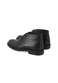 Schwarze Leder-Ankle-Boots mit glatter Oberfläche, subtilen Steppdetails und einem niedrigen Gummihighheel. Mit Ösen-Schnürung an der Vorderseite.