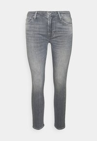 Jeans de denim gris ajustados con un acabado desgastado, diseño de cinco bolsillos y cierre de botón. Detalles de costura cerca de los bolsillos.