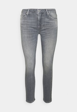 Wąskie, szare dżinsy o wytartym wykończeniu, pięciokieszeniowy model z zapięciem na guzik. Szyte akcenty w pobliżu kieszeni.