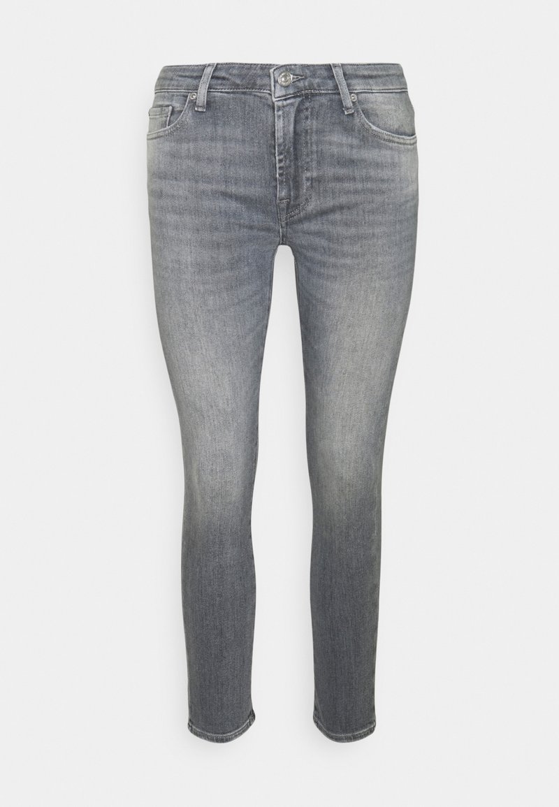 Jeans de denim gris ajustados con un acabado desgastado, diseño de cinco bolsillos y cierre de botón. Detalles de costura cerca de los bolsillos.