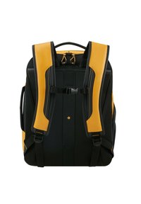 Sac à dos noir et jaune avec des bretelles rembourrées, texture en maille, sangle de poitrine réglable et une poignée en haut. Design épuré avec des accents contrastants.
