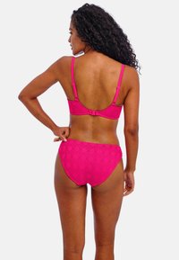 Ensemble de bikini rose vif en tissu texturé avec un motif en losanges, dotée de bretelles réglables et d'une fermeture à clip au dos.