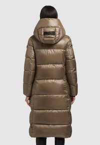 Lang, dunjakke i metallisk brun farve med en stor hætte, quiltet design og elastiske manchetter. Har et logo-detalje på ryggen.