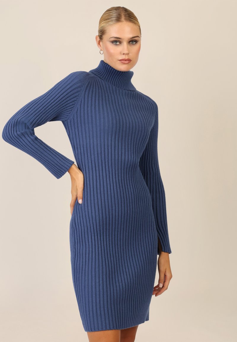 Abito a maglia a coste di un blu intenso con collo alto e maniche lunghe. Silhouette aderente con orlo dritto e dettaglio con spacco laterale.