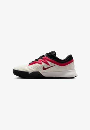 Sapatilha desportiva de cano baixo com parte superior em creme, sobreposição zigzag em vermelho, logótipo Nike em vermelho, atacadores pretos, colarinho preto e sola em preto e branco.