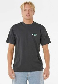 Donkergrijze katoenen t-shirt met een ronde hals en een klein turquoise logo op de borst. Korte mouwen, relaxte pasvorm, gecombineerd met lichtblauwe jeans.