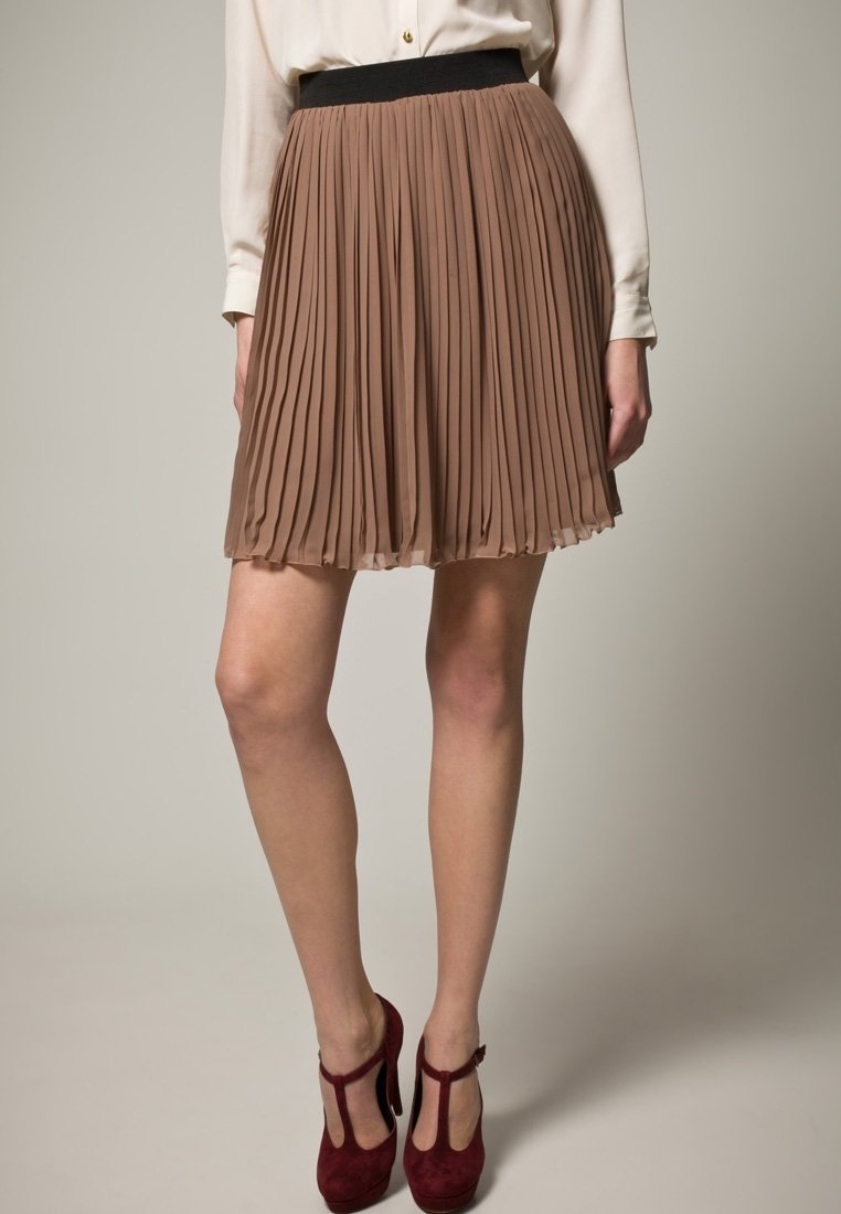 Falda marrón plisada con una cinturilla negra, que presenta un diseño fluido y una textura ligera, combinada con zapatos de tacón burdeos.