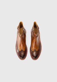 Botas de cuero marrón hasta el tobillo con un diseño ondulado, parte superior suave y punta estructurada, con un patrón texturizado en marrón oscuro en la parte delantera.