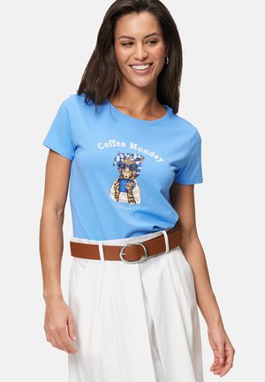 Blaues Baumwoll-T-Shirt mit einem grafischen Motiv eines Katers, der eine Sonnenbrille und einen Schal trägt, mit dem Text "Coffee Monday" in Weiß. Kombiniert mit einem braunen Gürtel.