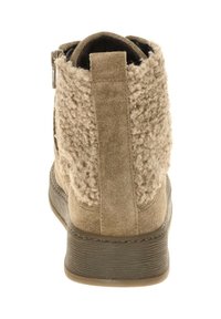 Beige enkellaars met een gestructureerd, fuzzy achterpaneel, gladde suede zijkanten en een rubberen zool met verticale groeven. Ritsdetail aan de zijkant.