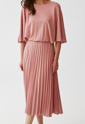 Różowa sukienka z plisowaniem, z dekoltem w kształcie łódki i szerokimi rękawami, uszyta z gładkiego materiału, o zwiewnej sylwetce, która sięga poniżej kolan.
