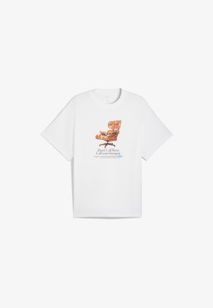 Hvid kortærmet t-shirt med en brun illustreret stoldesignet og teksten "Ring ikke til din snaps, ring til din terapeut."